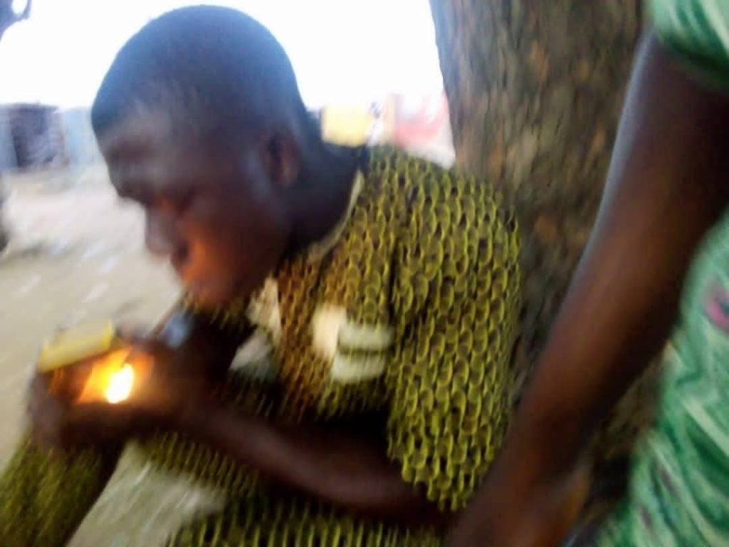 A smoker at the joint, lighting a stick of Indian Hemp