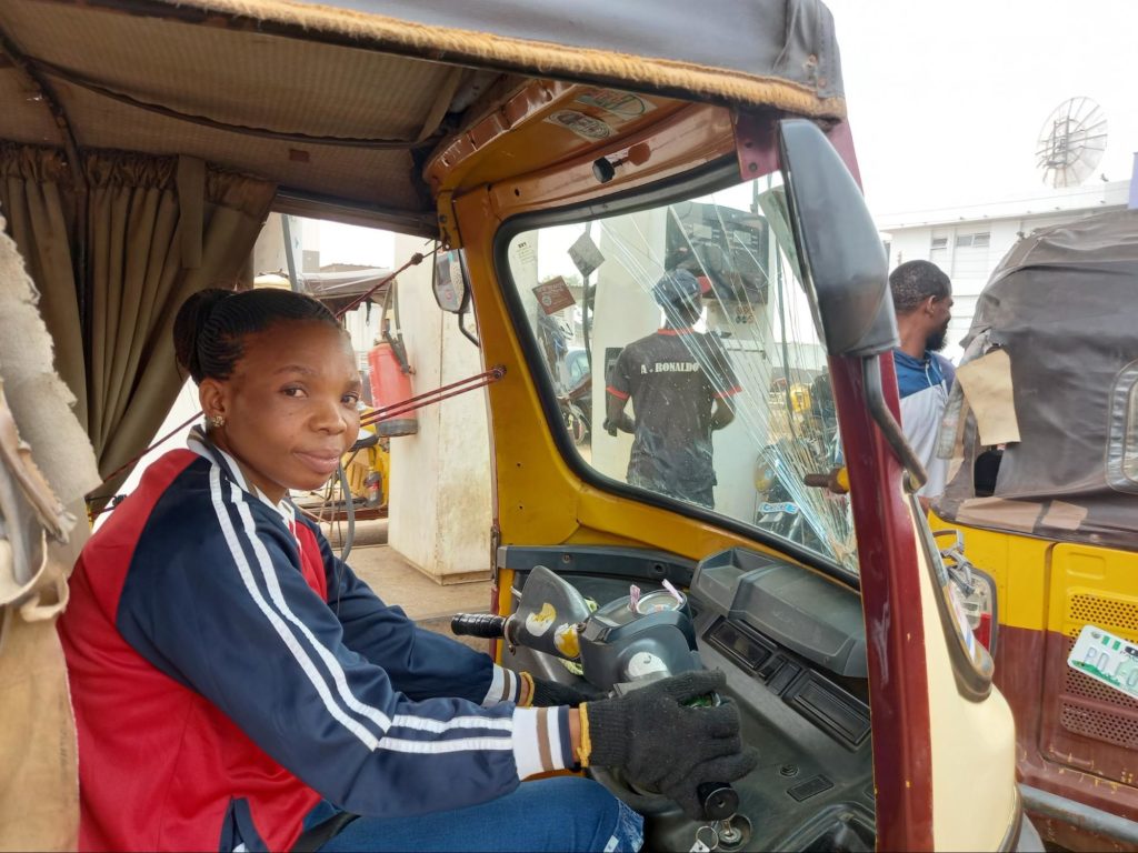 Ms. Iyabo queues to fuel her tricycle. 